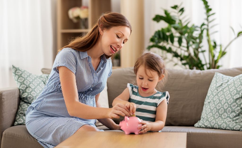 Single Mom and Child Putting Money in Piggy Bank Single Mom and Child Putting Money in Piggy Bank
