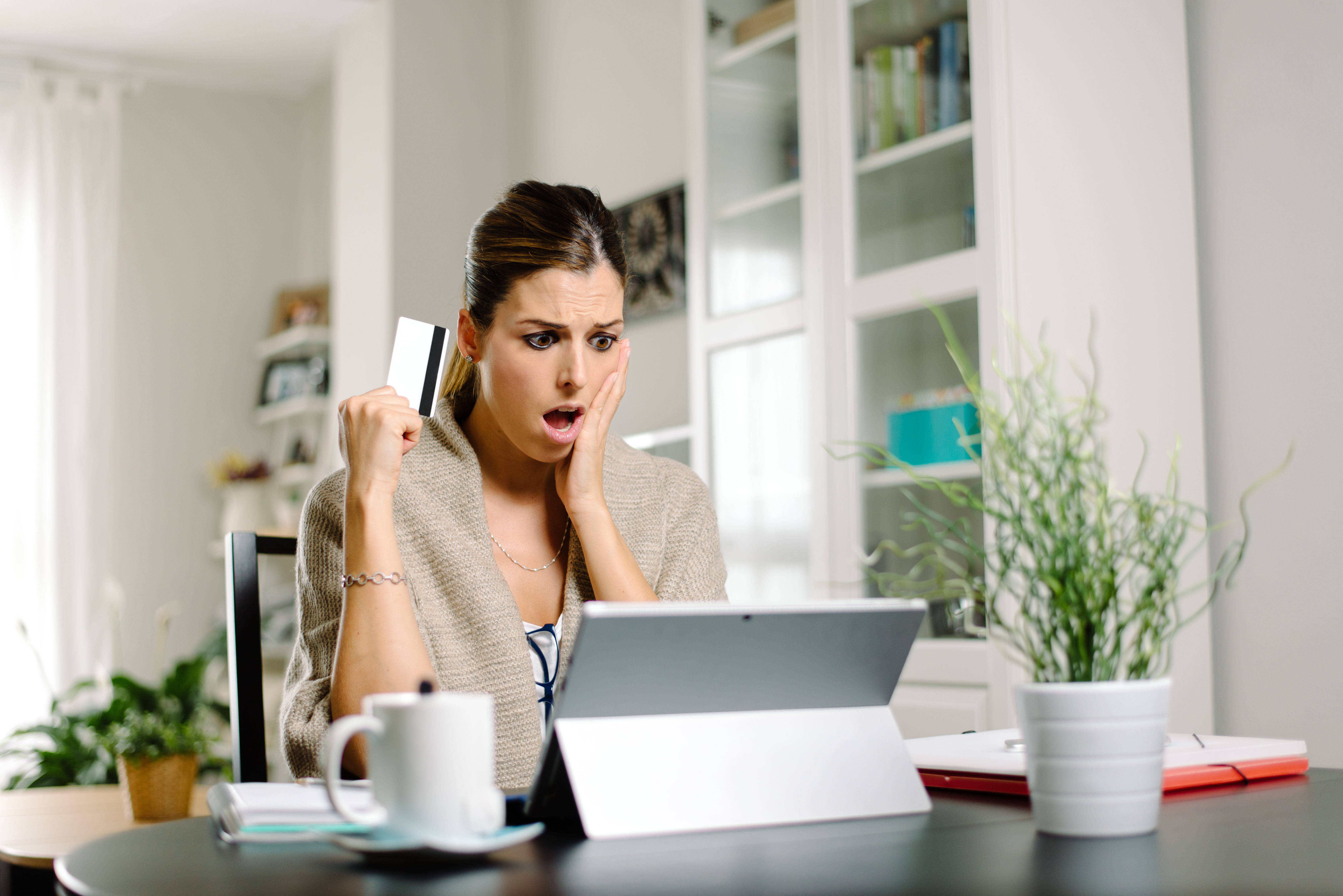 Woman Shocked with Credit Card in Hand Woman Shocked with Credit Card in Hand