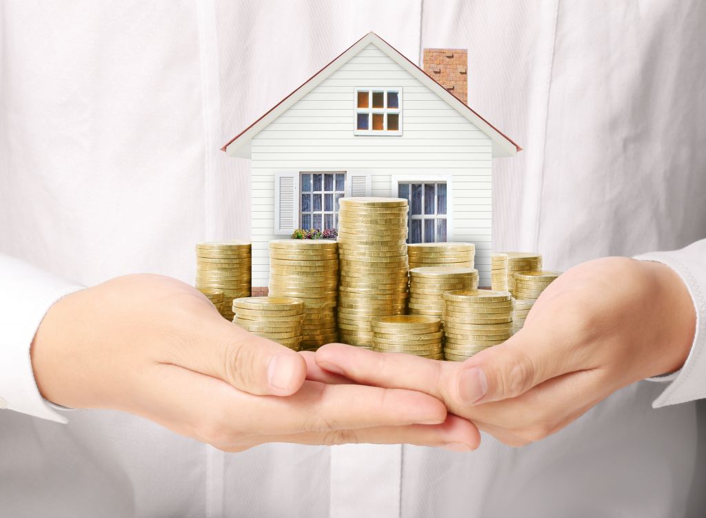 Woman Holding Little House and Gold Coin Stacks Woman Holding Little House and Gold Coin Stacks