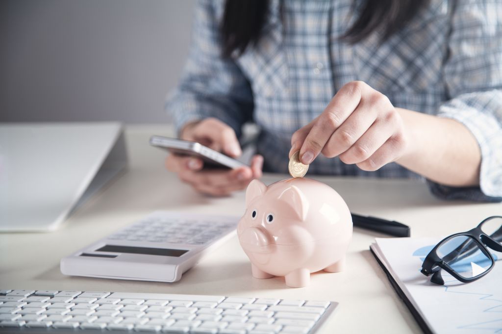 Man Putting Coin in Piggy Bank Man Putting Coin in Piggy Bank