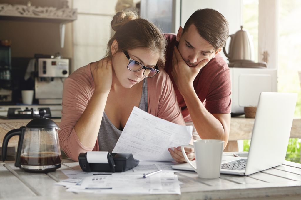 Couple Looking Over Taxes in Kitchen Couple Looking Over Taxes in Kitchen