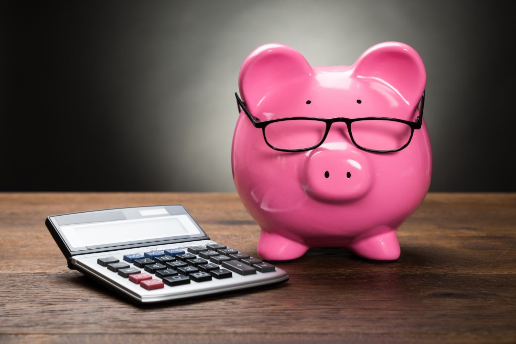 Piggy Bank and Calculator on Table Piggy Bank and Calculator on Table