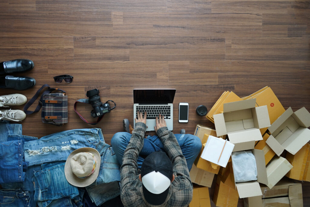 Man Shopping Online Surrounded by Open Deliveries Man Shopping Online Surrounded by Open Deliveries
