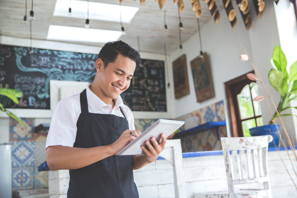 Small Business Owner Smiling at Tablet Small Business Owner Smiling at Tablet
