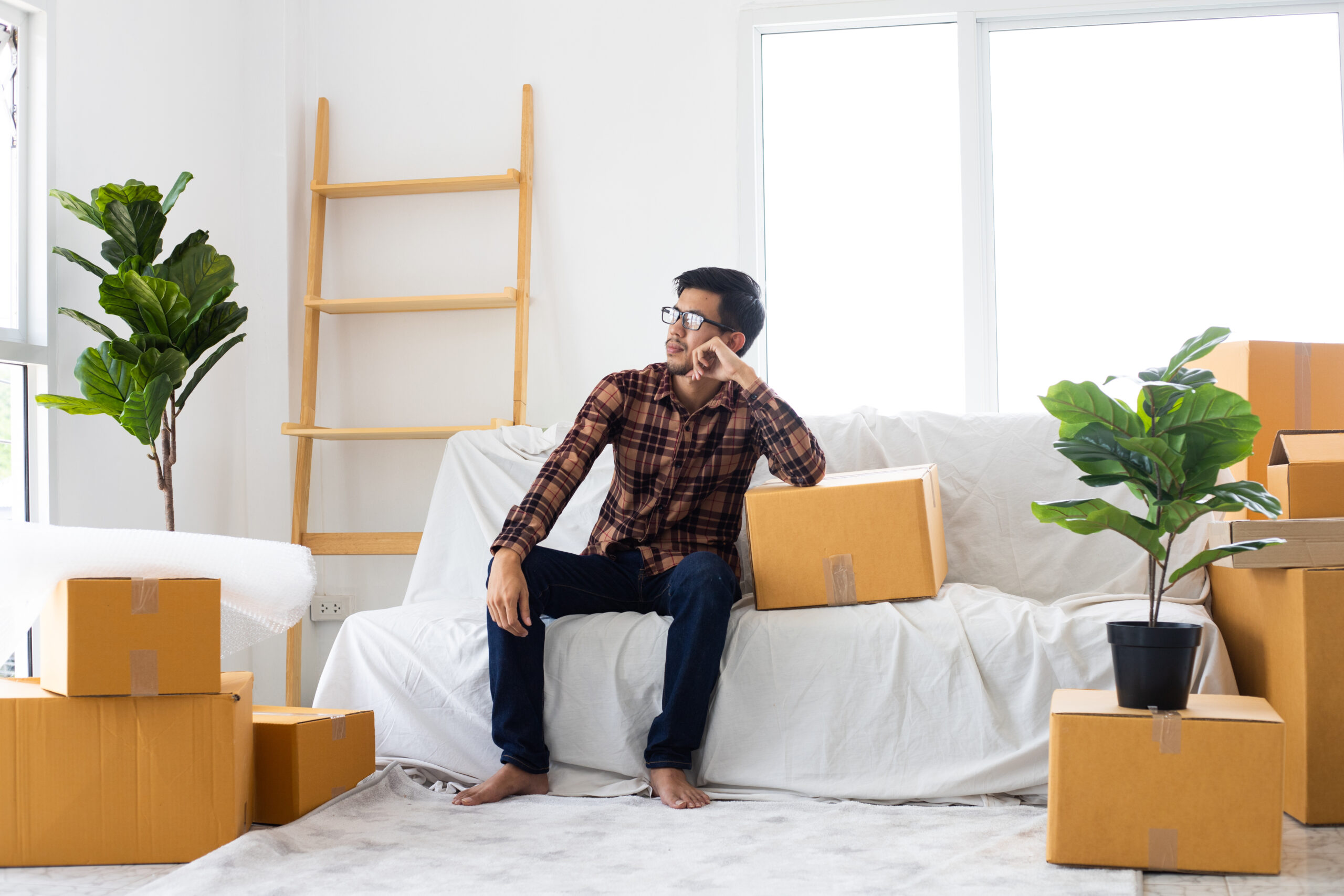 Man Sitting in Room of Moving Boxes Man Sitting in Room of Moving Boxes