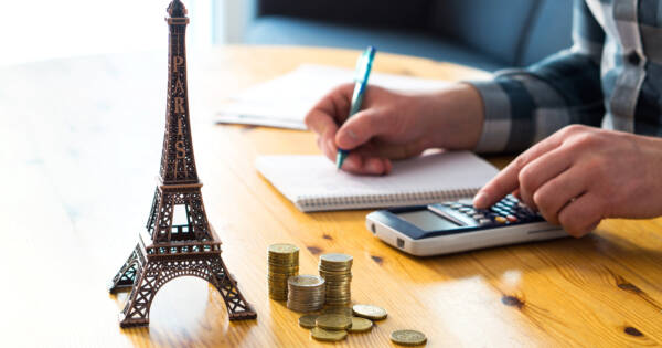 Eiffel Tower and Coins on Travel Agents Desk