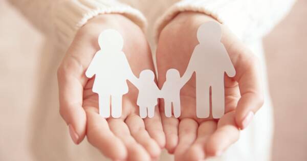 Woman Holding Paper Family in Hands