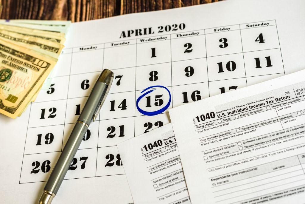 April 15th Circled on Calendar with Tax Forms April 15th Circled on Calendar with Tax Forms