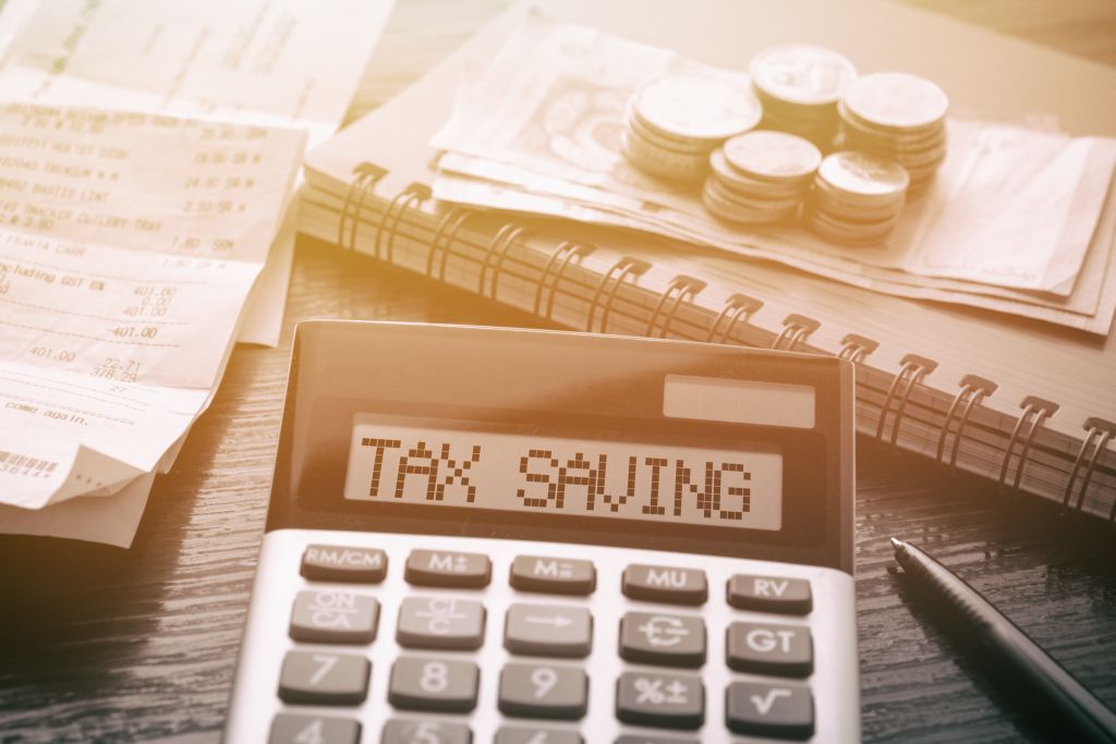 Desktop with Tax Savings on Calculator Desktop with Tax Savings on Calculator