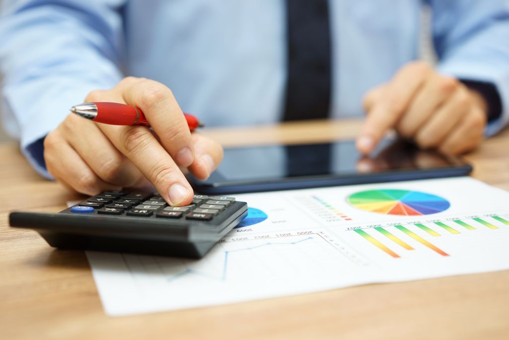 Man Crunching Numbers on Financial Charts Man Crunching Numbers on Financial Charts