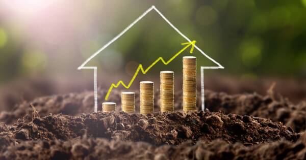 House and Coin Stack Accenting Upward Trend Graph