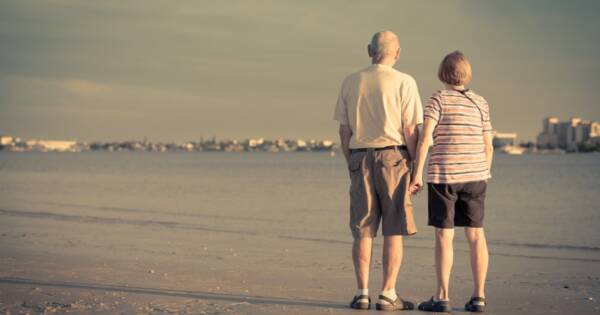 Retired Senior Couple Holding Hands at the Beach