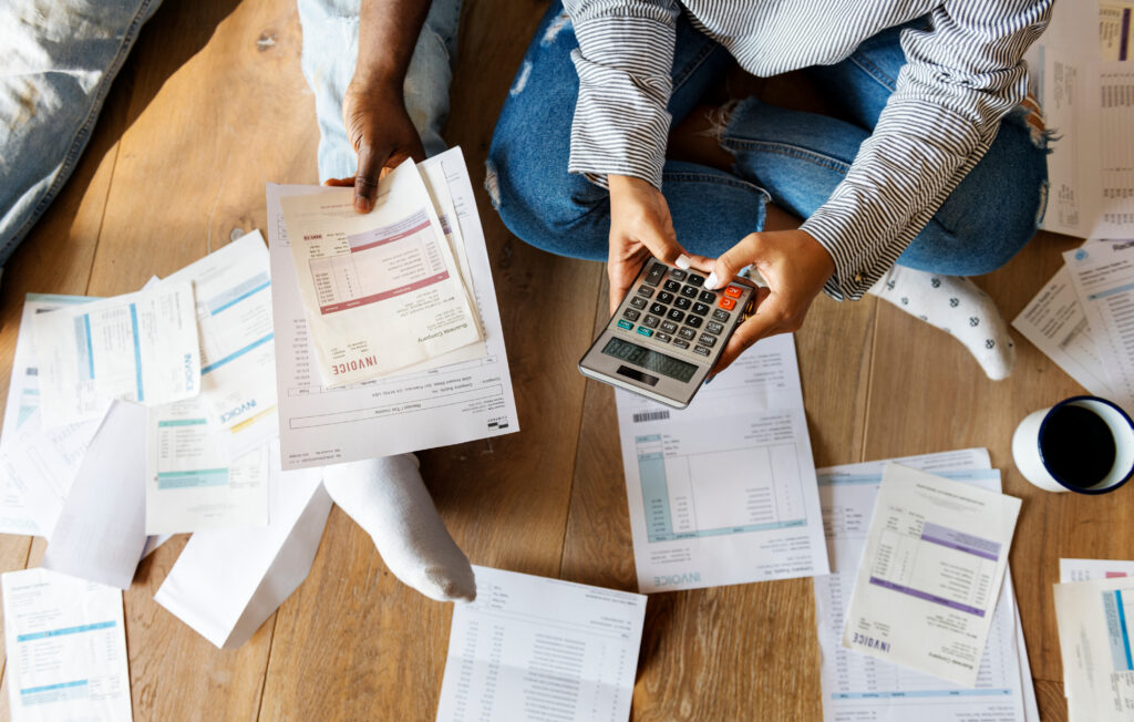 Calculating Debt with Invoices on Wood Floor Calculating Debt with Invoices on Wood Floor