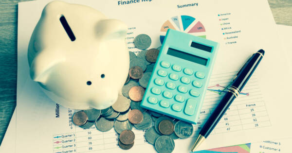 Piggy Bank and Calculator on Top of Finance Report