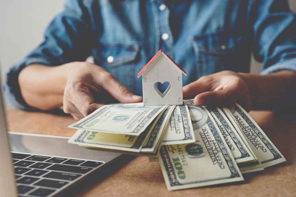 Man Holding Mini Home & Money Man Holding Mini Home & Money