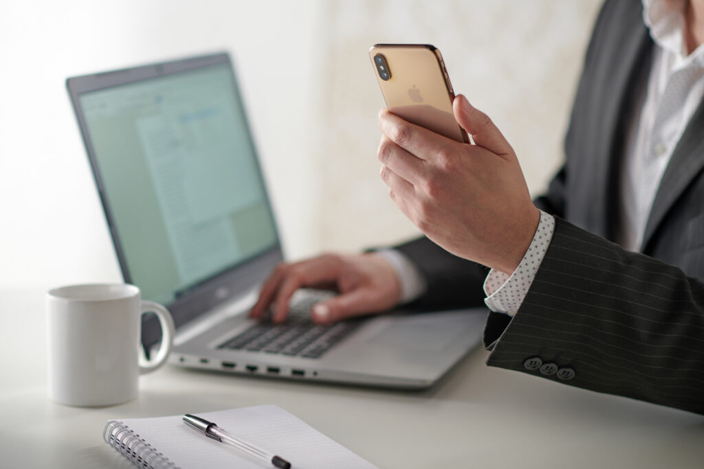Man Looking at Website on Phone and Laptop Man Looking at Website on Phone and Laptop