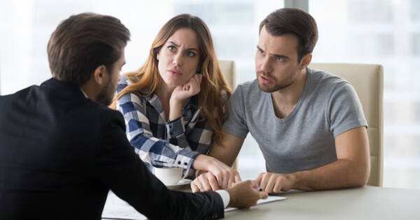 Couple Discussing Rental Scam with Business Professional