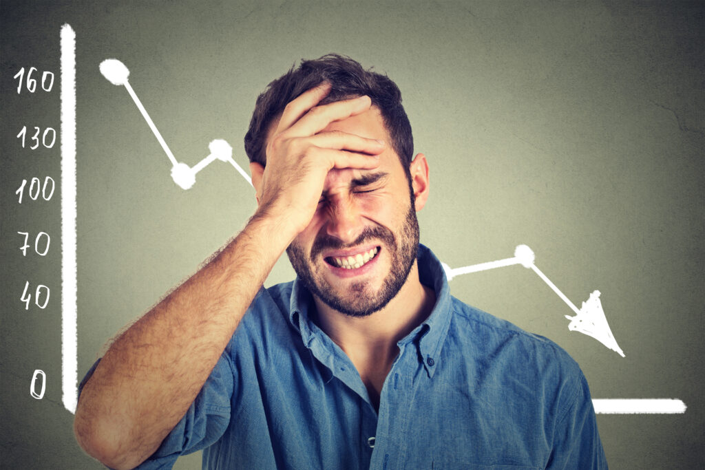 Man Upset with Financial Decline Chart Behind Him Man Upset with Financial Decline Chart Behind Him